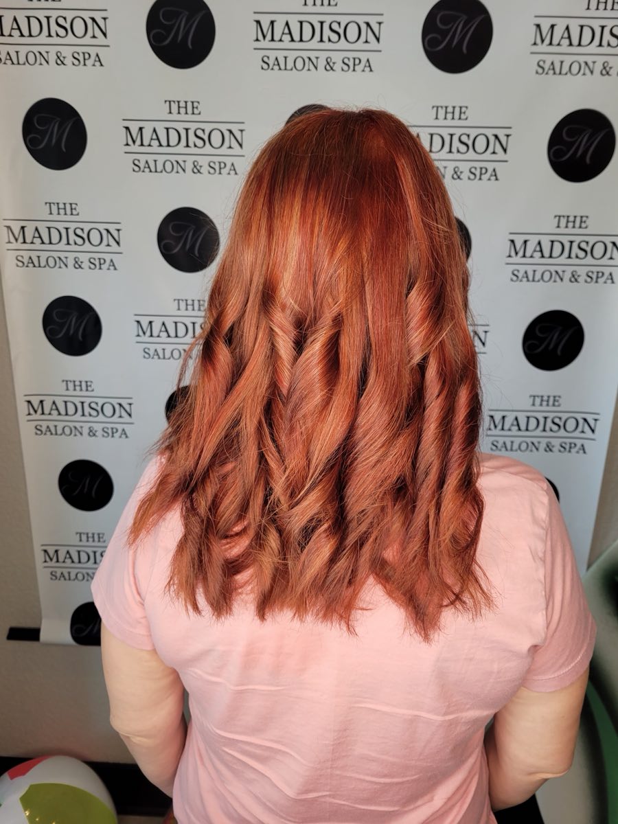 Vibrant copper-red color and styling done at The Madison Salon & Spa