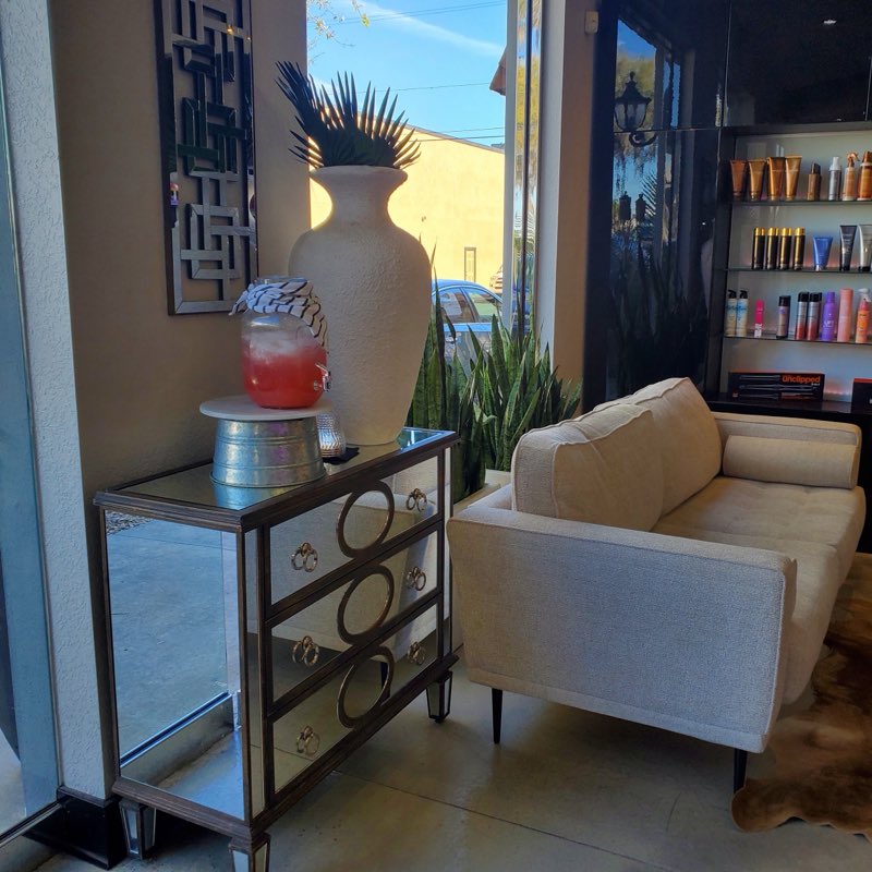 Upscale waiting area with cream sofa and product shelves